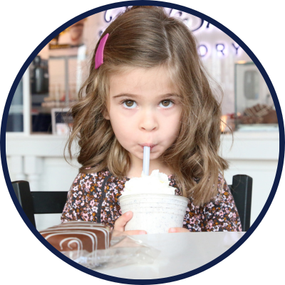 A person enjoying gourmet milkshakes at a dessert franchise, highlighting a fun and family-friendly atmosphere.