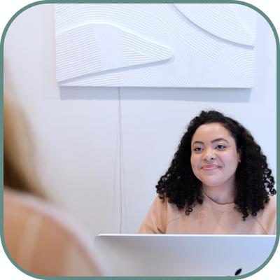 An employee at a sugaringLA location interacting with a customer behind a desk, providing personalized service and assistance.