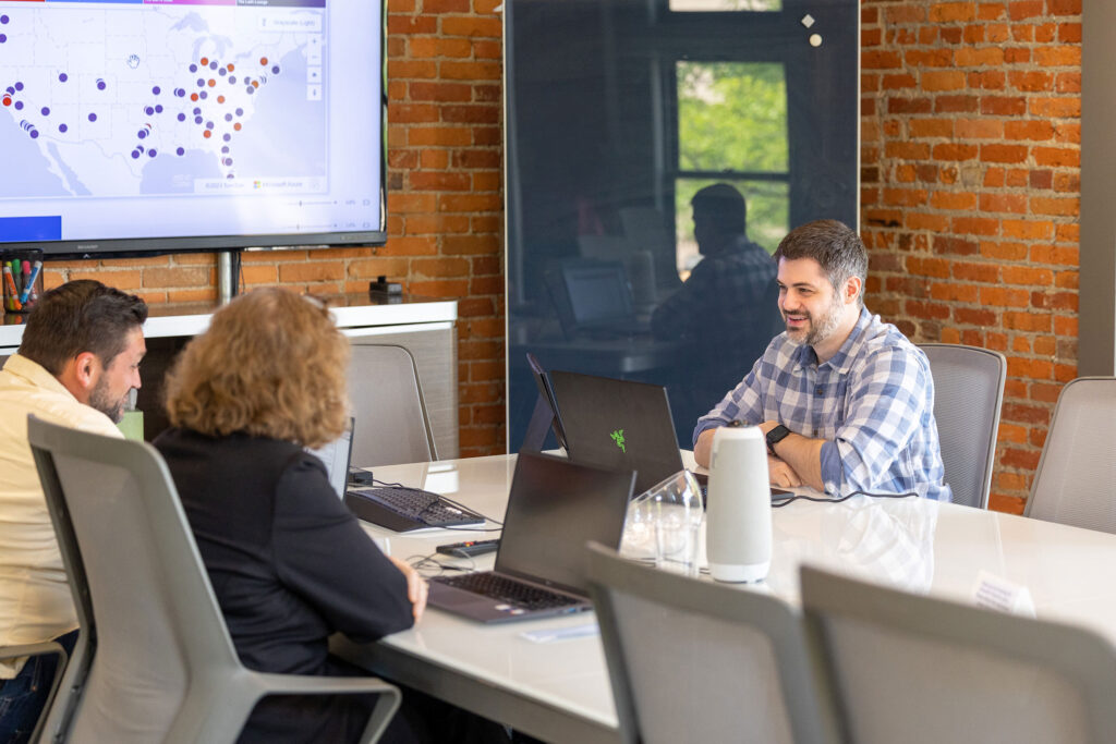 People at a conference table discussing franchise opportunities, starting a franchise, and the benefits of owing a franchise. 