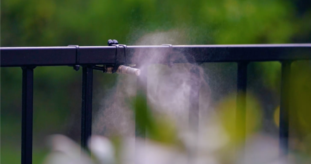 Close-up of mosquito misting system spraying non-toxic pest control solution