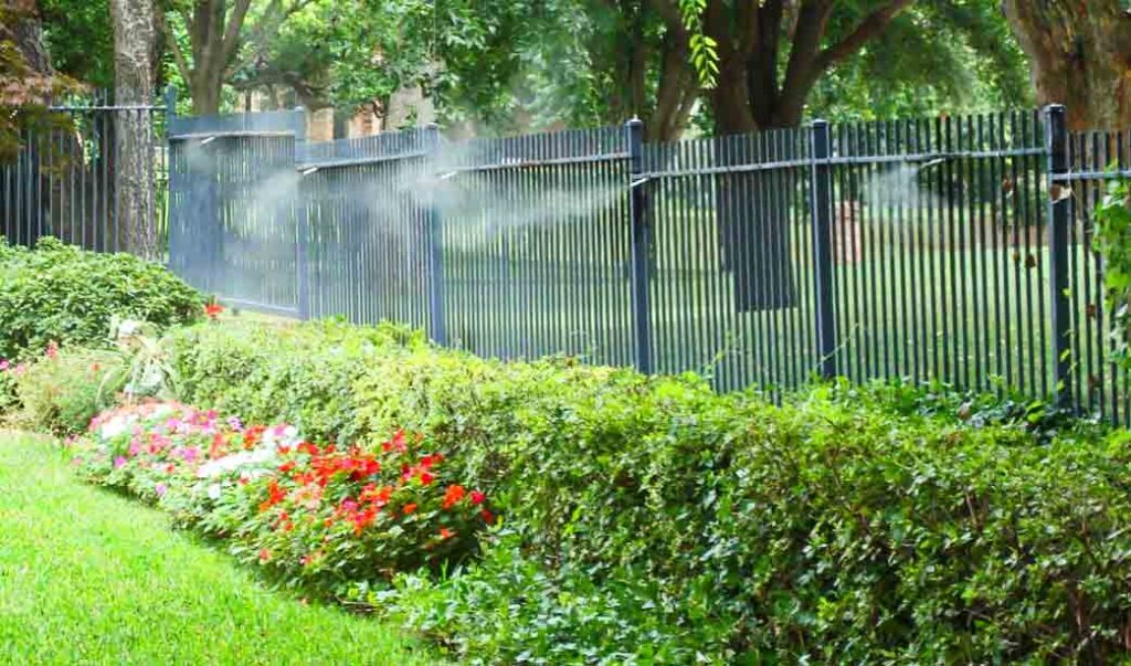 MosquitoNix misters installed on a fence in a lush backyard