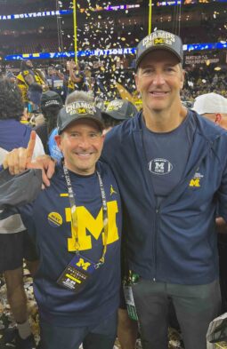 Paul Blavin and John Rotche posing together at a Michigan Football game, both influential in franchise opportunities.