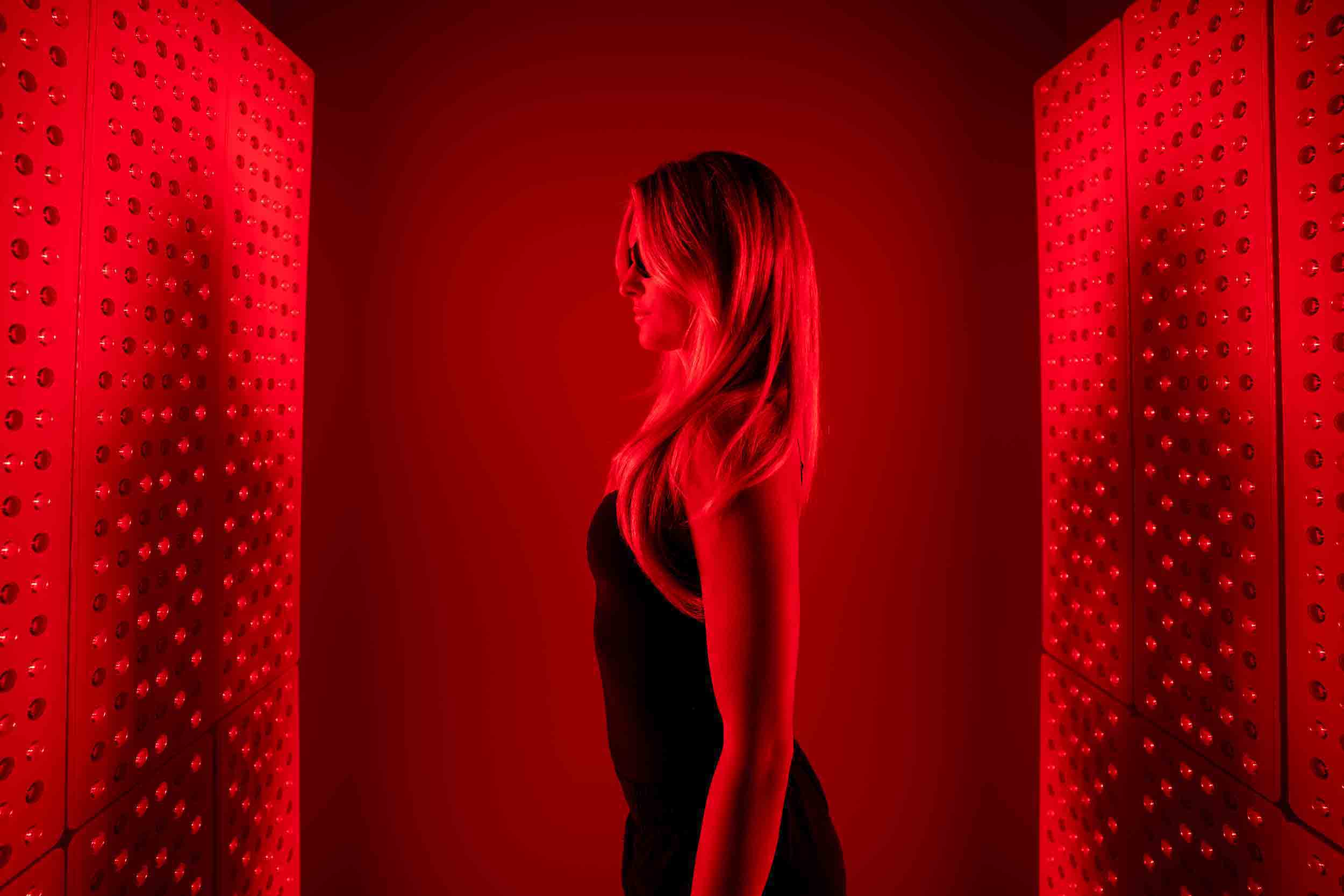 A person undergoing red light therapy, a health and recovery service offered by wellness franchises.