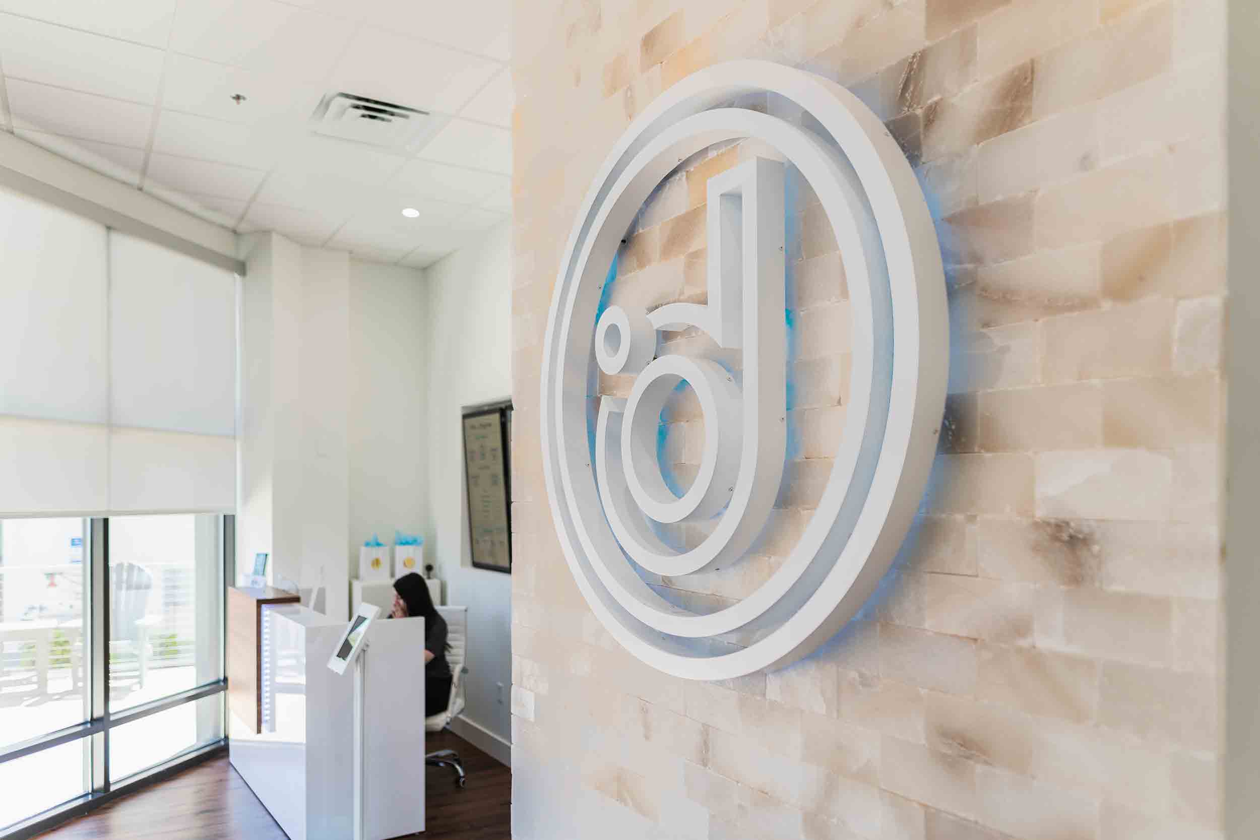 Front desk of a Degree Wellness Clinic with an employee sitting, offering cold plunge, infrared sauna, and IV therapy services.