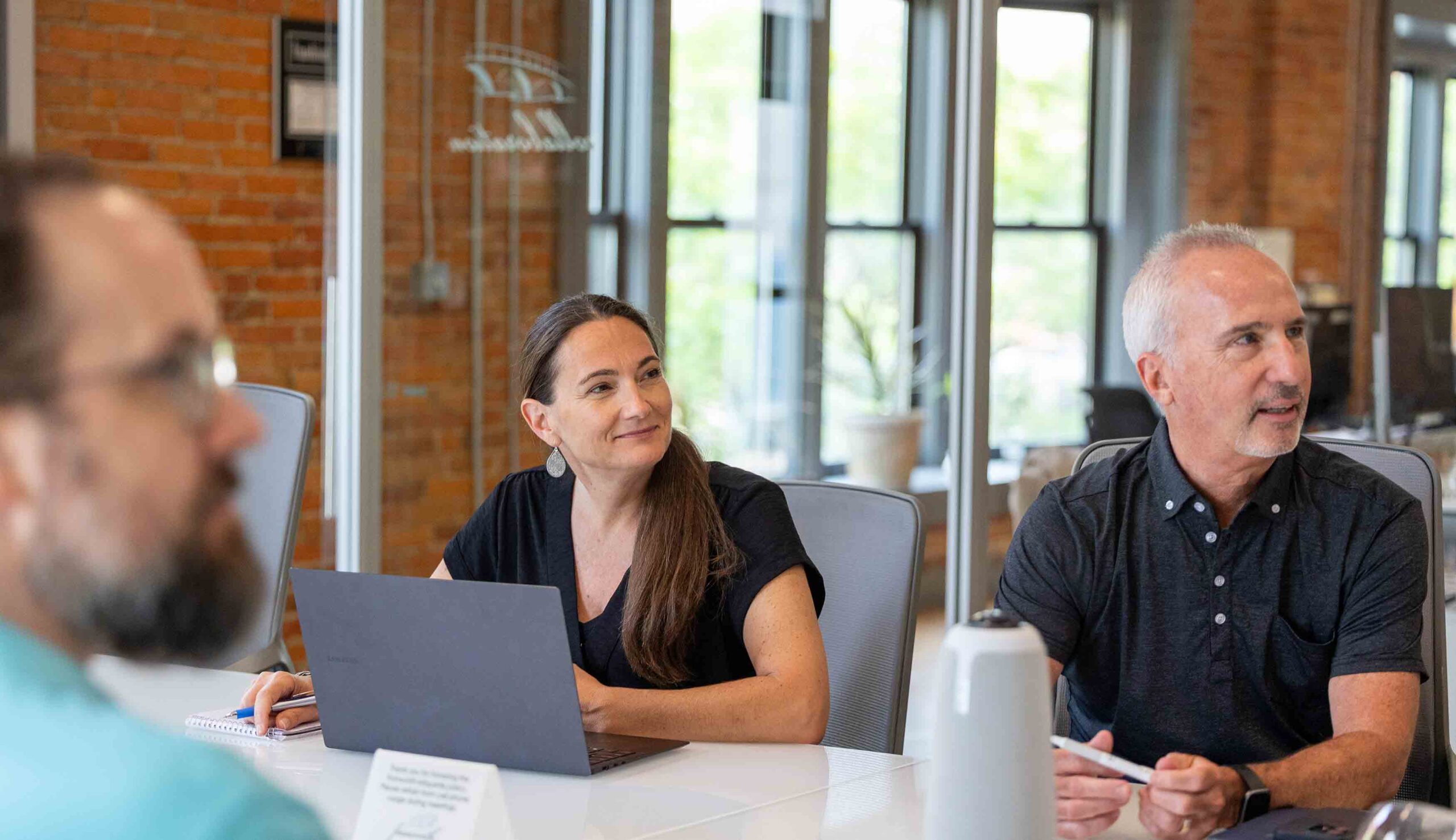 A group of people sitting around a table in a conference room