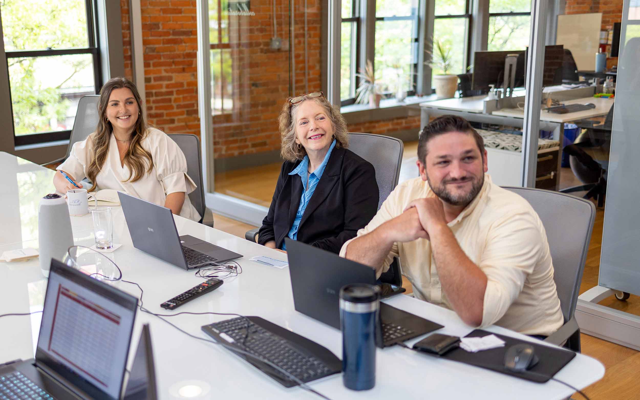 Three business professionals working together at a conference table, exploring franchise business opportunities.